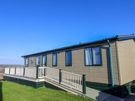 A holiday cabin with a deck and windows at 91 Swanage Coastal Park in Swanage