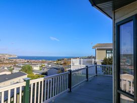 A balcony view of the sea and town at 91 Swanage Coastal Park in Swanage