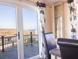 A living room with a view through the door at 91 Swanage Coastal Park in Swanage