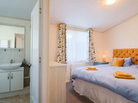 A bedroom with a bed and a mirror at 91 Swanage Coastal Park in Swanage