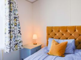 A bedroom with a bed and bedside lamp at 91 Swanage Coastal Park, Swanage