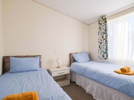 A bedroom with two beds and a lamp at 91 Swanage Coastal Park in Swanage
