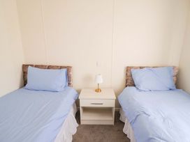 A bedroom with two single beds and a nightstand at 91 Swanage Coastal Park in Swanage