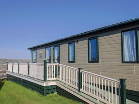 A house with a deck and windows at 91 Swanage Coastal Park in Swanage