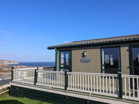 A building with a deck and ocean view at 91 Swanage Coastal Park in Swanage