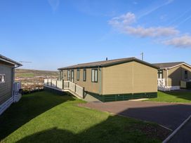 A mobile home with a deck and pathway at 91 Swanage Coastal Park in Swanage