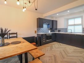 A kitchen with a dining table and chairs at Green Bank in Betws-Y-Coed