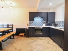 A kitchen with cabinets and appliances at Green Bank in Betws-Y-Coed