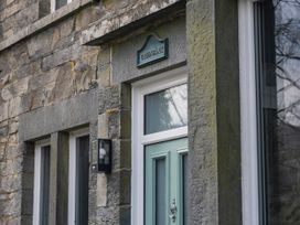 An entrance with a green door and stone wall at Green Bank in Betws-Y-Coed
