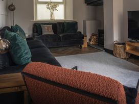 A living room with a sofa, television, and a fireplace at Green Bank in Betws-Y-Coed