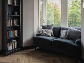 A living room with a sofa and bookshelf at Green Bank in Betws-Y-Coed