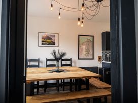 A dining room with a wooden table and chairs at Green Bank in Betws-Y-Coed