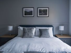A bedroom with a bed and framed pictures at Green Bank in Betws-Y-Coed