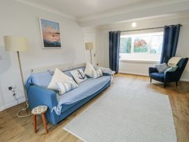 A living room with a sofa and armchair at 16 Ffordd Meigan Beaumaris