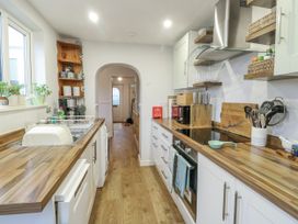 A kitchen with cabinets and appliances at 16 Ffordd Meigan Beaumaris