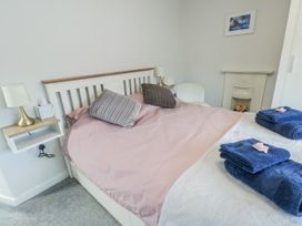 A bedroom with a bed and pillows at 16 Ffordd Meigan Beaumaris