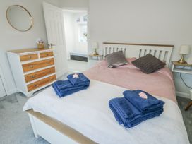 A bedroom with a double bed and dresser at 16 Ffordd Meigan Beaumaris