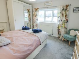 A bedroom with a double bed and wardrobe at 16 Ffordd Meigan Beaumaris