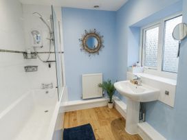 A bathroom with a bathtub and sink at 16 Ffordd Meigan Beaumaris