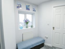 A hallway with a bench and flower vase at 16 Ffordd Meigan Beaumaris