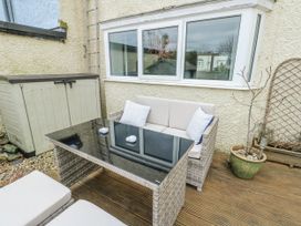 An outdoor seating area with a table and sofa at 16 Ffordd Meigan in Beaumaris