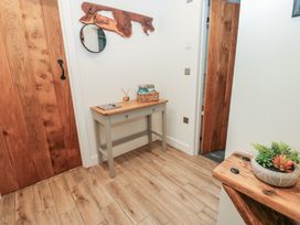 A hallway with a table and a mirror at Cobble Cottage Long Marton near Appleby-In-Westmorland