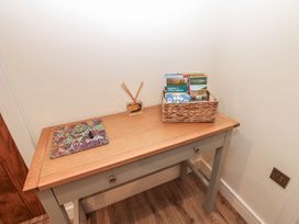 A table with a basket of magazines and a room fragrance in the hallway at Cobble Cottage Long Marton near Appleby-In-Westmorland