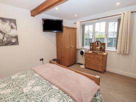 A bedroom with a bed, wardrobe, and television at Cobble Cottage in Long Marton near Appleby-In-Westmorland