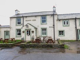 An exterior view of Masons Arms pub with benches in front at Cobble Cottage Long Marton near Appleby-In-Westmorland