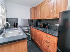 A kitchen with appliances and wooden cabinets at Captain Jacks in Whitby