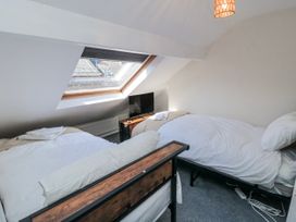 A bedroom with two beds and a television at Captain Jacks in Whitby
