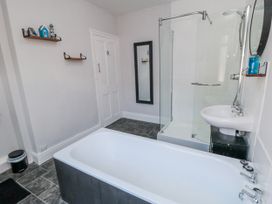 A bathroom with a bathtub, shower, and sink at Captain Jacks in Whitby