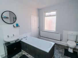 A bathroom with a bath tub, sink, and toilet at Captain Jacks in Whitby