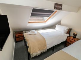 A bedroom with two beds and a television at Captain Jacks in Whitby