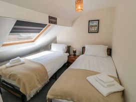 A bedroom with two single beds and a window at Captain Jacks in Whitby