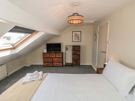 A bedroom with a bed, television, and dresser at Captain Jacks in Whitby