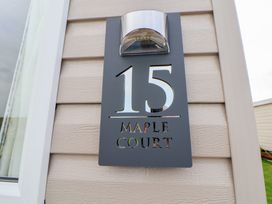 A house sign showing number 15 and name Maple Court