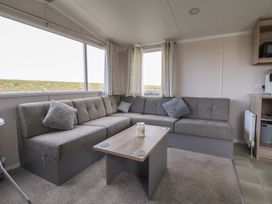 A living room with a sofa and table at MC15 in Rhyl