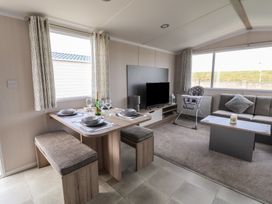 A living room with a dining table and sofa at MC15 Rhyl
