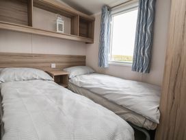 A bedroom with two single beds and a window at MC15 in Rhyl