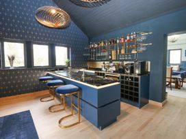 A kitchen with a blue island and bar stools at Chapel Hill in Catlowdy