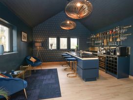 A home bar with stools and shelves at Chapel Hill in Catlowdy