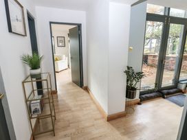A hallway with a plant stand and doors at Chapel Hill in Catlowdy