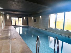 An indoor pool area with windows and a swimming pool at Chapel Hill in Catlowdy