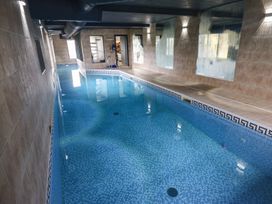 A swimming pool with tiled walls and mirrors at Chapel Hill in Catlowdy