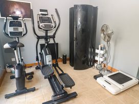 A gym with fitness equipment including an elliptical trainer and exercise bike at Chapel Hill Catlowdy