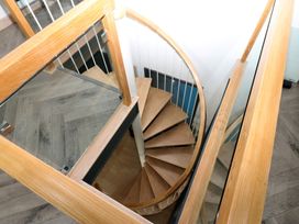A spiral staircase with a glass railing at Chapel Hill in Catlowdy