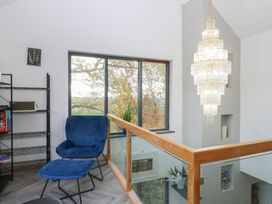 A landing area with a blue chair and chandelier at Chapel Hill in Catlowdy