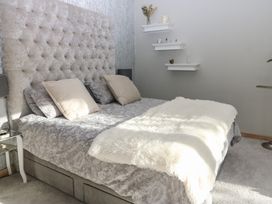 A bedroom with a bed and wall shelves at Chapel Hill, Catlowdy