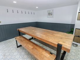 A dining room with a wooden table and benches at Chapel Hill in Catlowdy